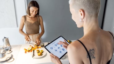Woman controls smart kitchen appliances with mobile device