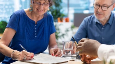 Mature woman signing retirement planning contract to secure the pension
