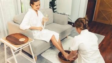 Woman indulges in blissful foot massage at luxurious spa salon while masseur give reflexology therapy in gentle day light ambiance resort or hotel foot spa Quiescent