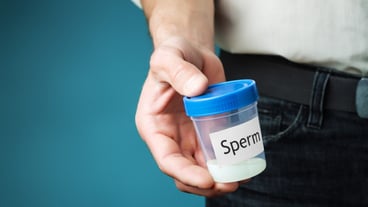 Container with sperm in a hand